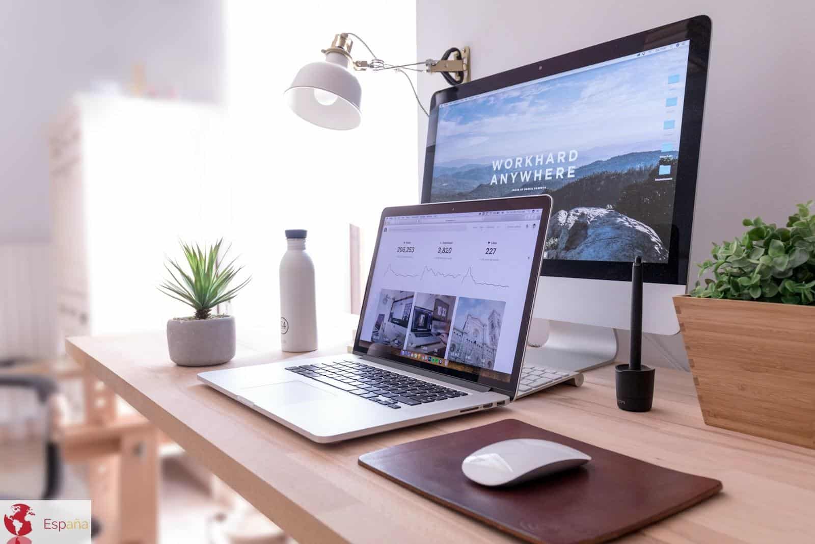 MacBook Pro on table beside white iMac and Magic Mouse