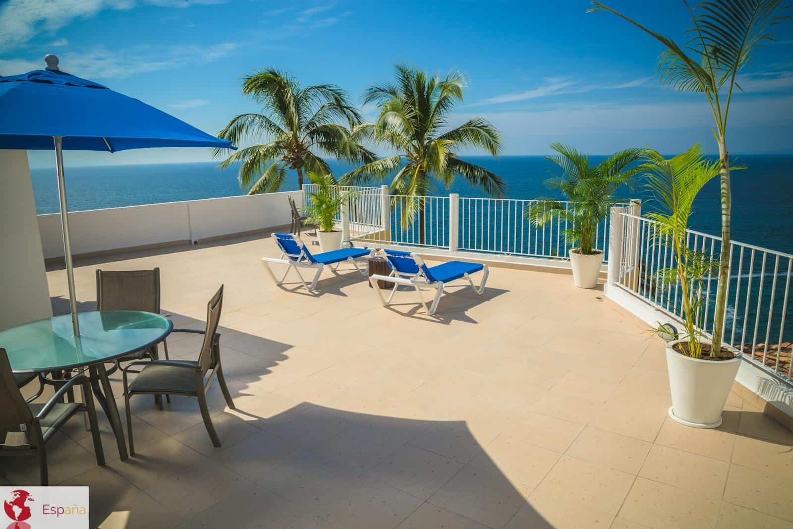 Blue Loungers on Beige Balcony Beside Sea Landscape Photography