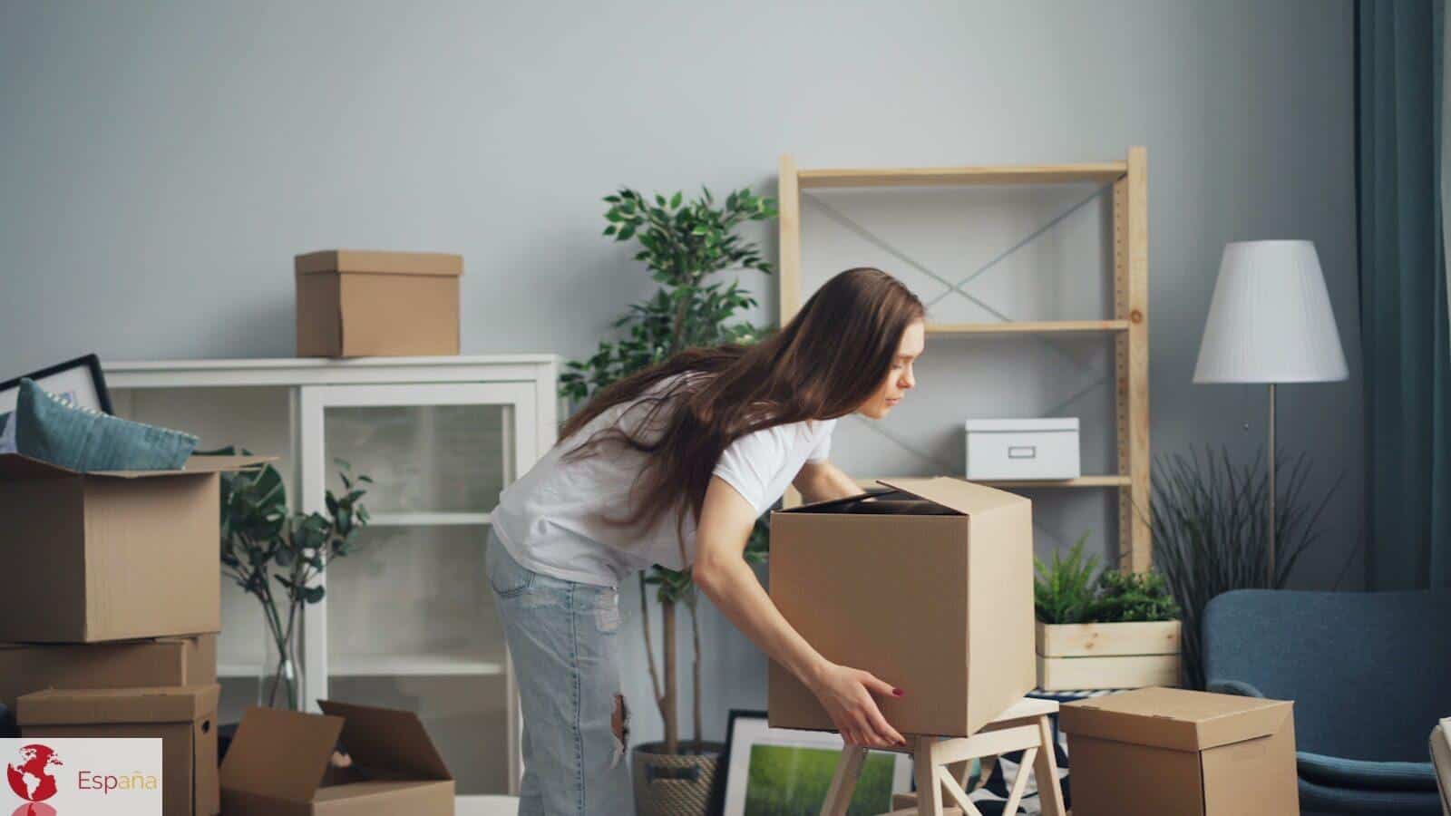a woman moving boxes in a living room