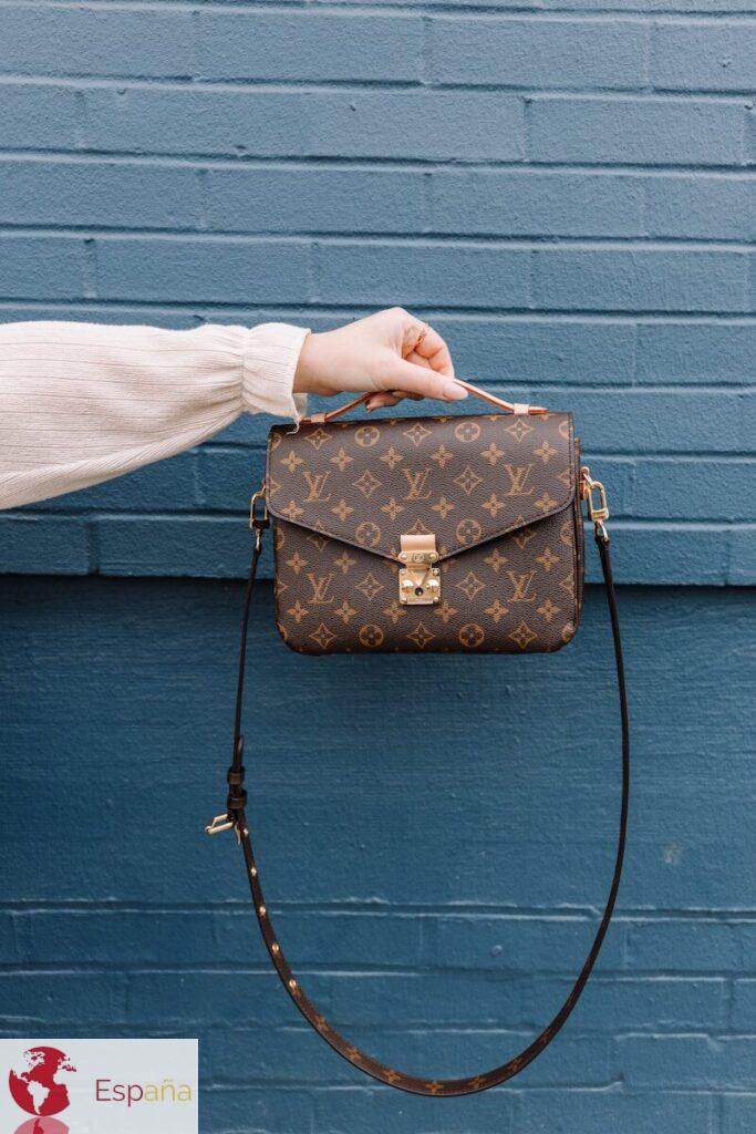 person holding brown leather sling bag