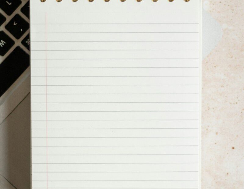 Escritorio de redacción con portátil y cuaderno de notas